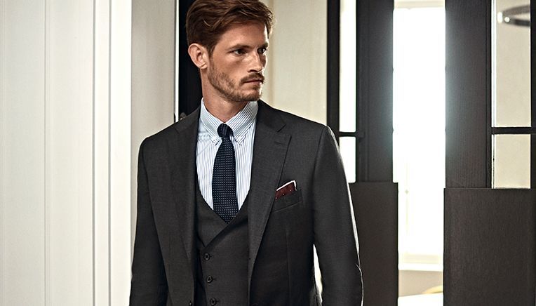 Senszio model in a dark grey custom made suit, including waistcoat, smart shirt and complimenting tie