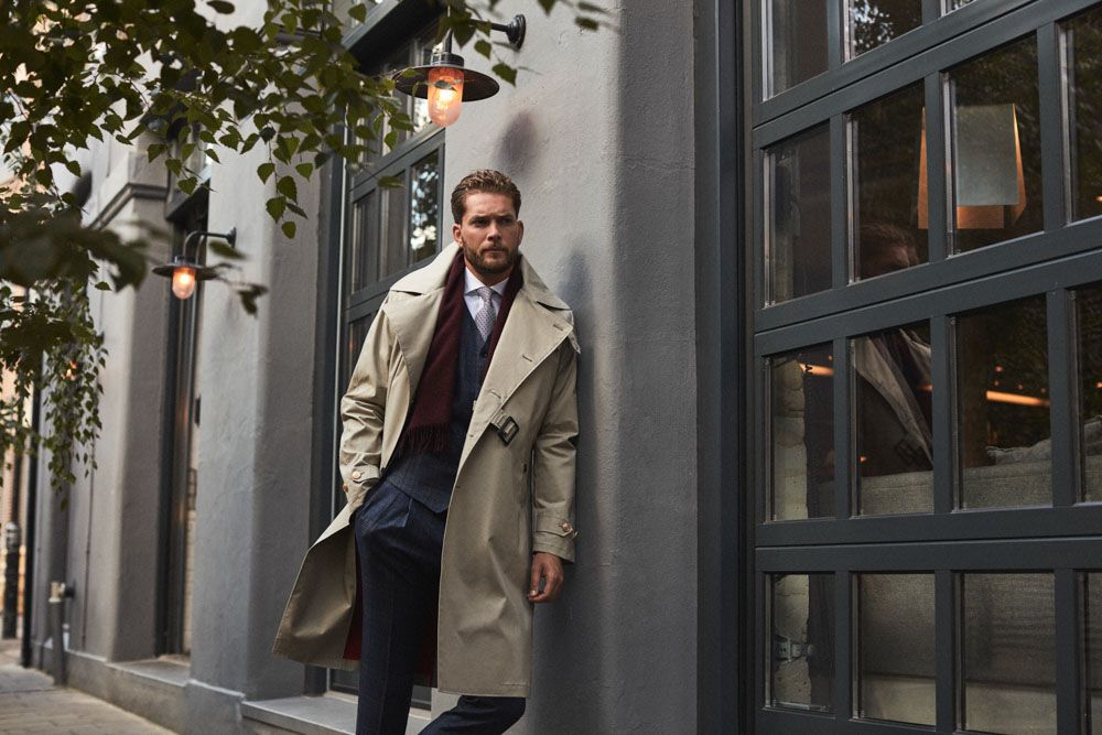 Man in custom tailored trench coat from Senszio, in classic camel and partnered with a suit.